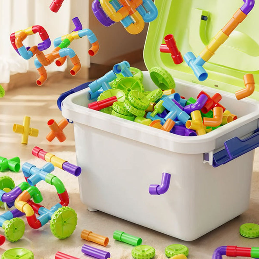 Boîte de rangement remplie de tuyaux colorés, avec des constructions autour