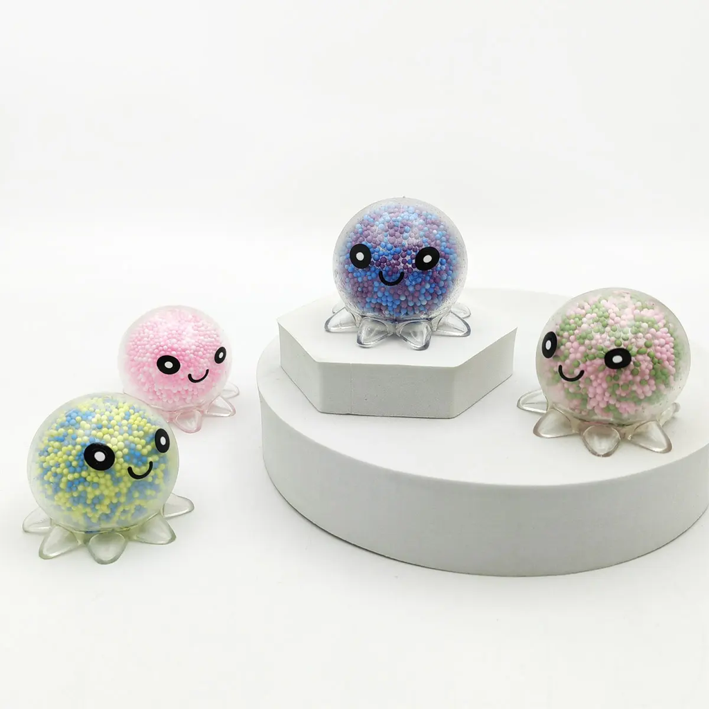 Quatre poulpes anti-stress à billes de mousse alignés : bleu et violet, rose, jaune et bleu, rose et vert