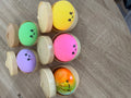 Squishys bao anti-stress jaune, vert, rose, violet et multicolore posés près de leurs paniers vapeur ouverts