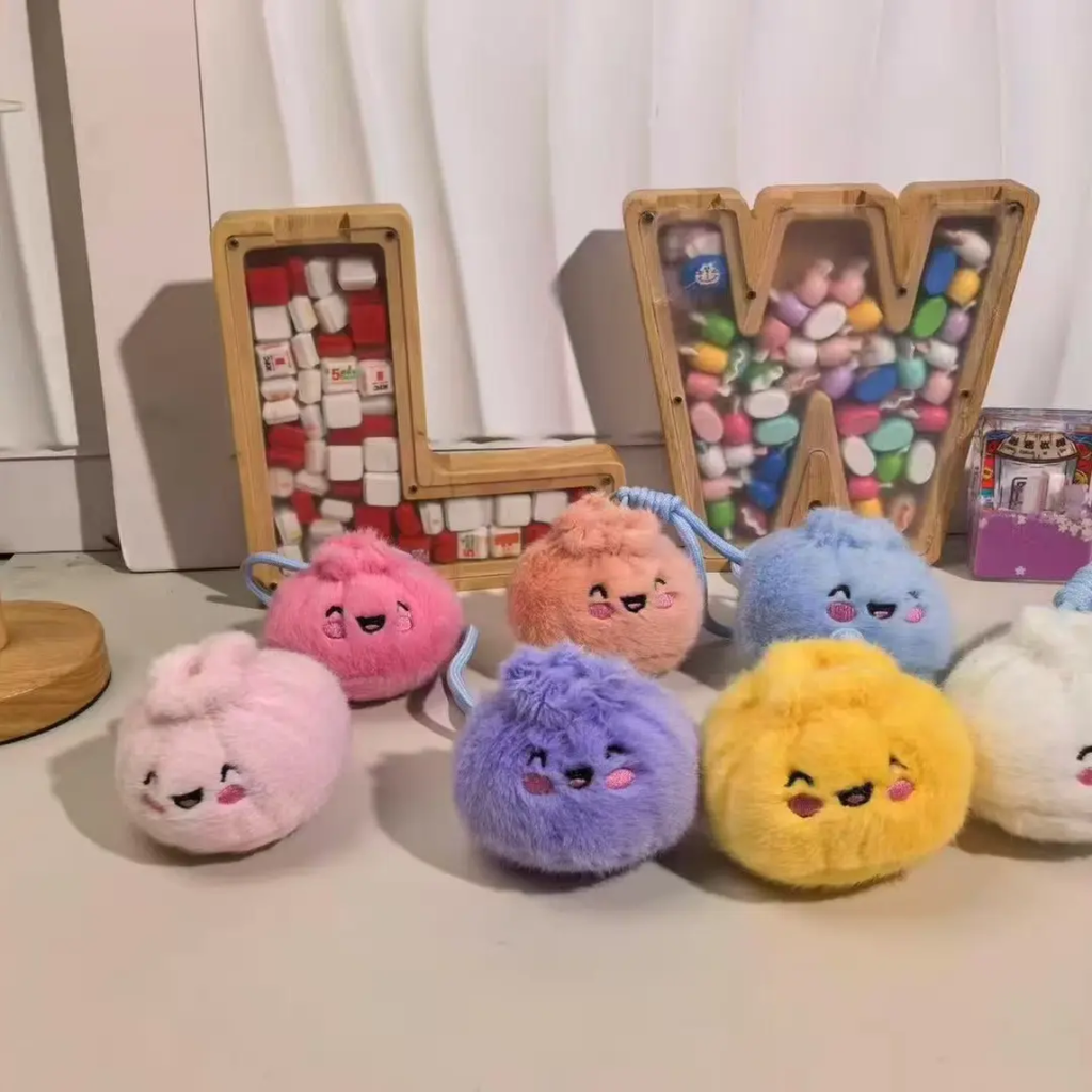 Peluche boulette kawaii rose au visage souriant dans sa boîte
