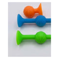 Trois fléchettes ventouses souples orange, bleue et verte posées sur une surface claire