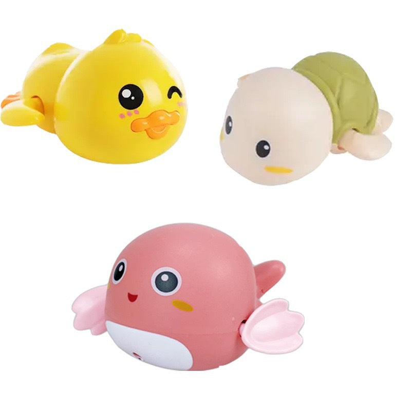 Canard jaune, tortue beige et baleine rose à remontoir sur fond blanc